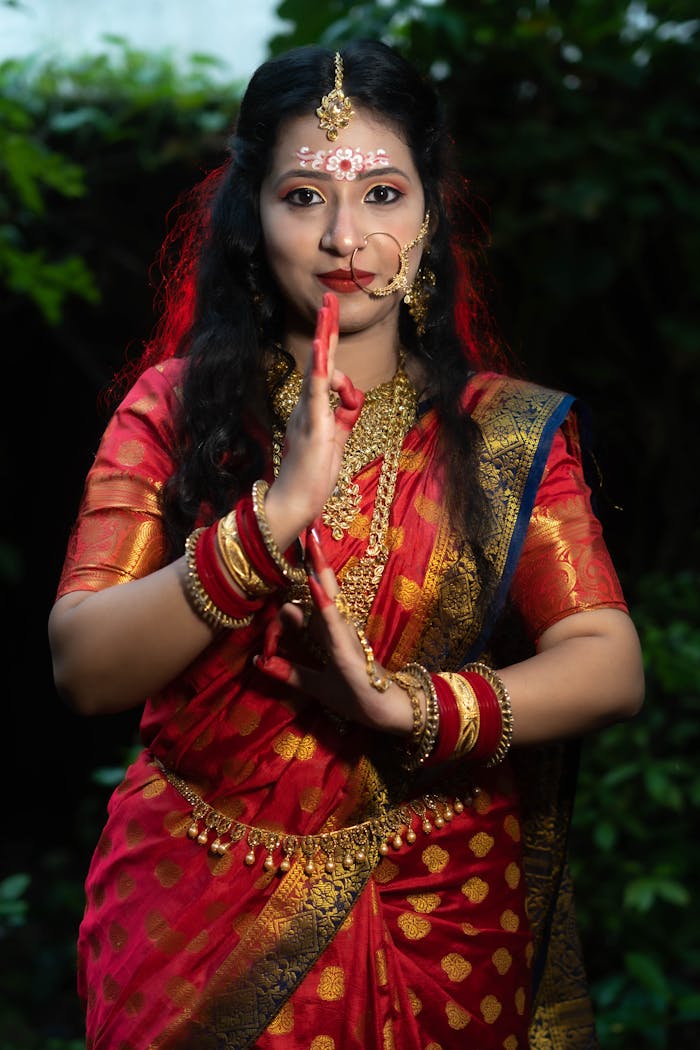 Portrait of an Indian woman in a traditional red sari performing a cultural dance.